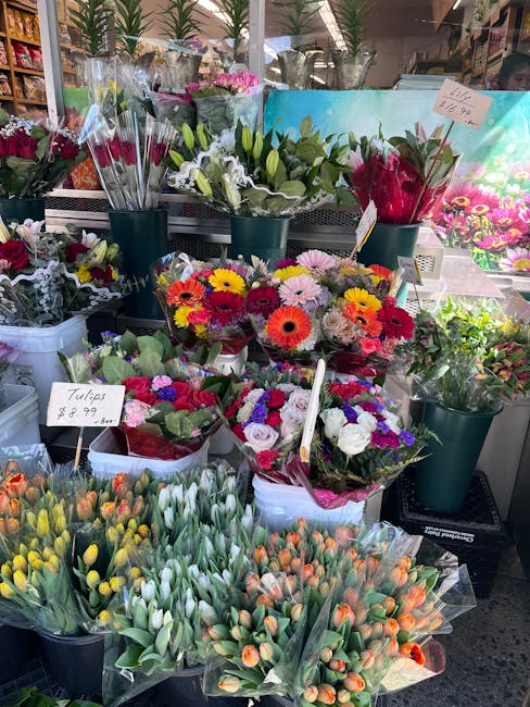 A vibrant display of fresh floral arrangements and flower bouquets on a market stall at floristpinner.co.uk, featuring a variety of colorful blooms including tulips, daisies, roses, and chrysanthemums